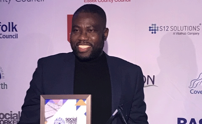 Solomon holding his Student Social Worker of the Year award