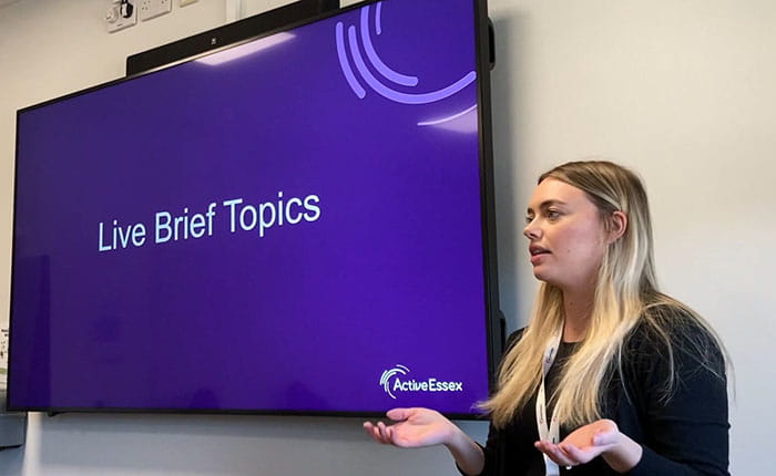 Courtenay Mosley, Active Essex Relationship Manager, speaking in front of a television screen 