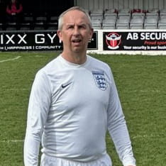 Adrian Owers standing on a football pitch in England kit