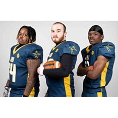 Three people dressed to play American football