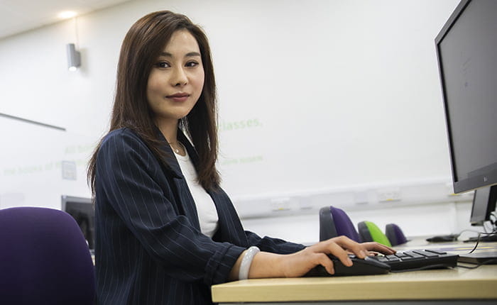 ARU student April sitting at a computer