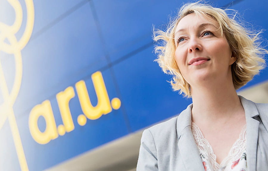 A student looking into the distance outside the Lord Ashcroft Building on ARU's Chelmsford campus
