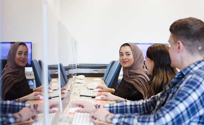 Three students using iMacs at Cambridge School of Art