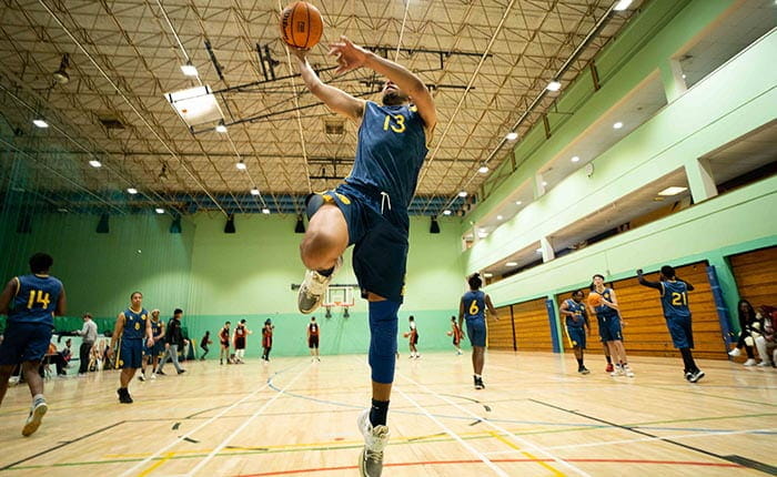ARU basketball player doing a layup in the arena