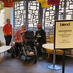 A member of ARU staff with two members of the public and a baby in a pram at the Cambridge Breastfeeding Support Hub
