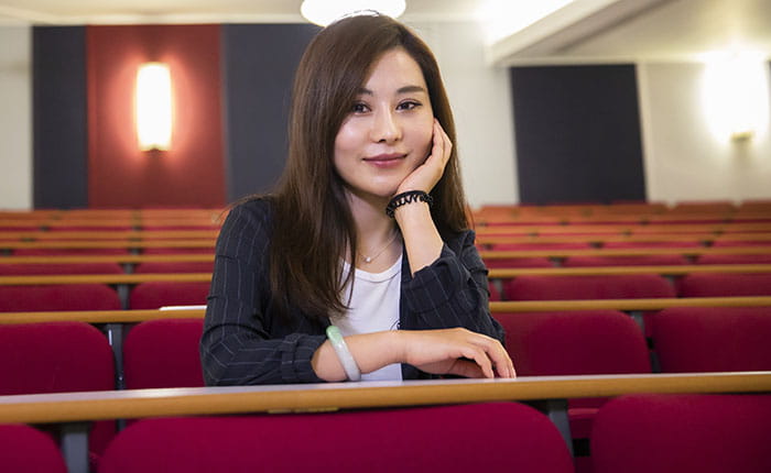 Student April sitting in an empty lecture theatre