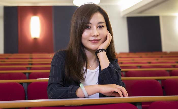 Student April sitting in an empty lecture theatre