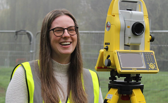 Chartered Surveyor Degree Apprentice Ciara using surveying equipment