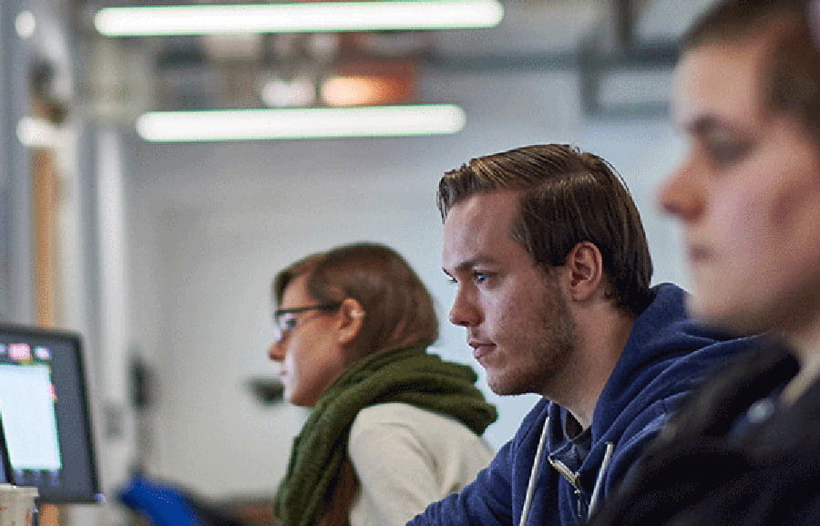 Three students looking at computers