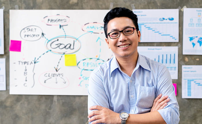 iStock image of Man smiling in front of presentation board