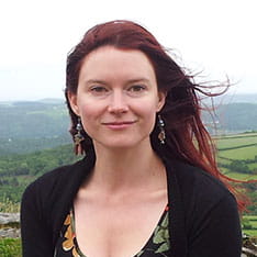 Head shot of Anglia Ruskin lecturer, Dannielle Green, stood outside with fields in the background