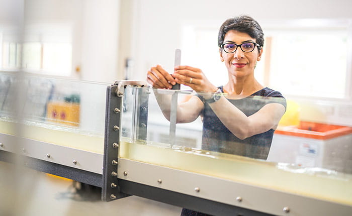 A woman works with lab equipment at ARU