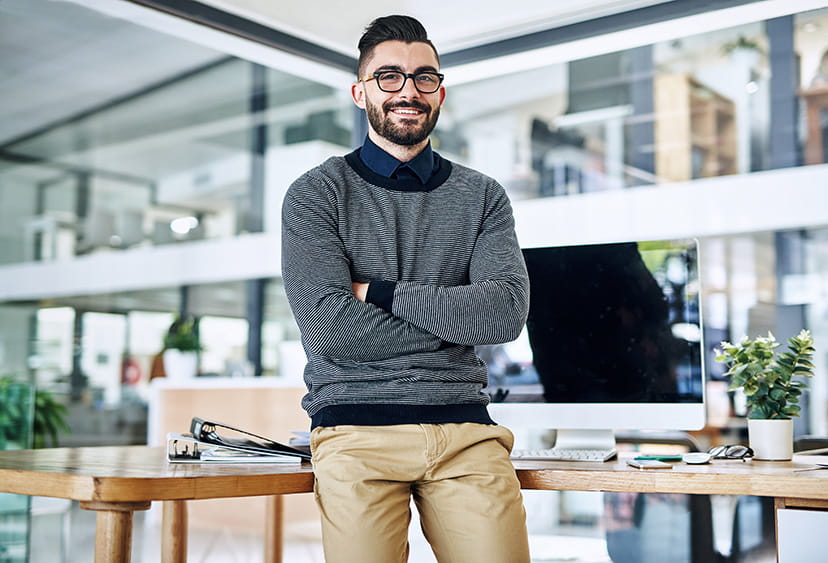 A man in a modern office, smiling at the camera