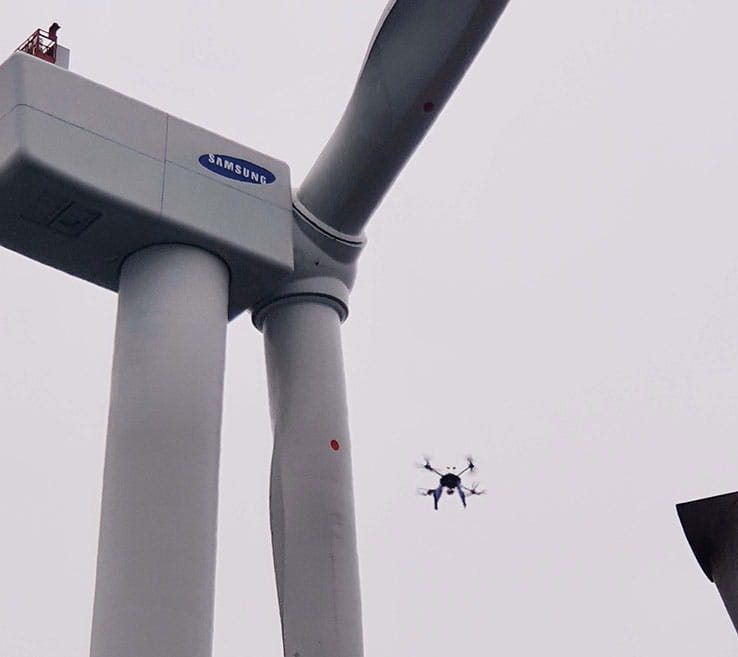 A drone flying near a wind turbine