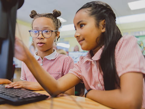 Two schoolchildren working together on a computer