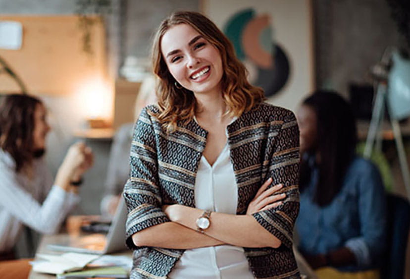 Woman in office - two colleagues seen in background