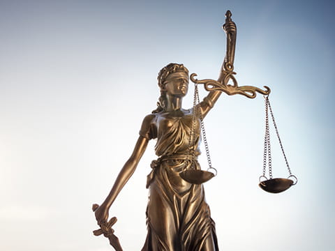 A statue of Lady Justice, blindfolded and holding a sword and a set of scales