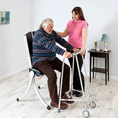 A young carer assisting an older person to use a mobility aid