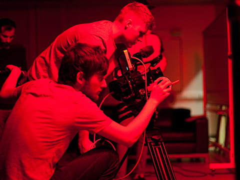 Two students operating film camera equipment