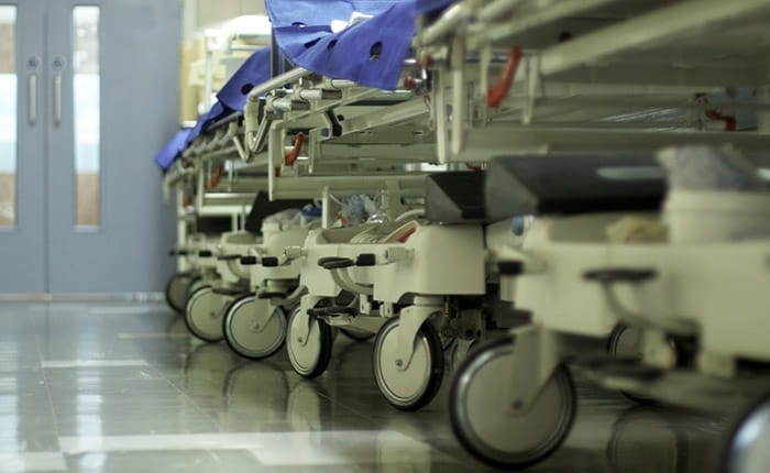 A row of hospital gurney in a corridor, as viewed from the floor