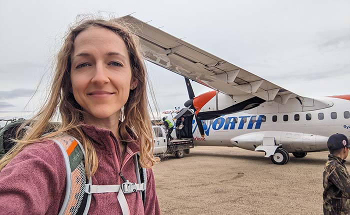 Researcher Georgia Hole in front of an AirNorth plane in the Arctic