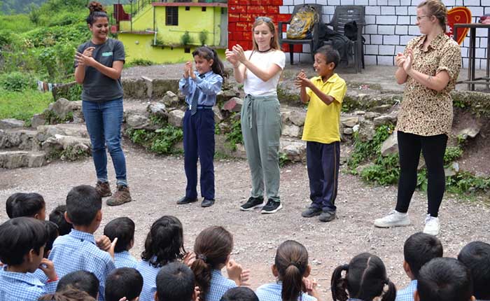 International Community Experience members dancing in playground with school children