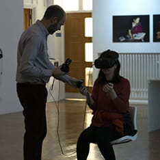 Fabrizio Galeazzi helping a person use a VR headset at the Ruskin Gallery