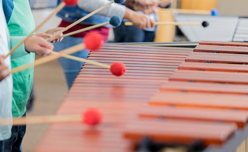 Children's hands using beaters on xylophones