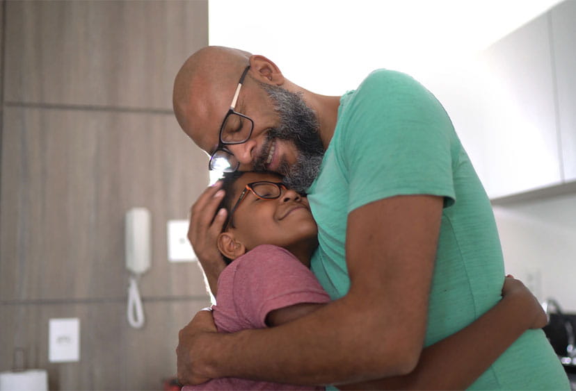 An adult and a child standing and hugging each other