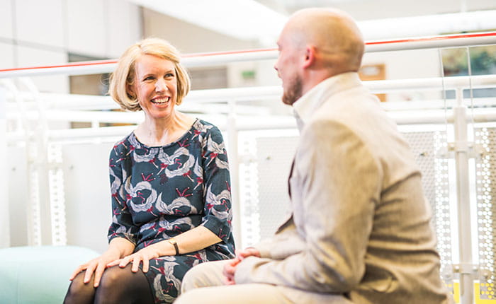 Two smartly-dressed people having a conversation