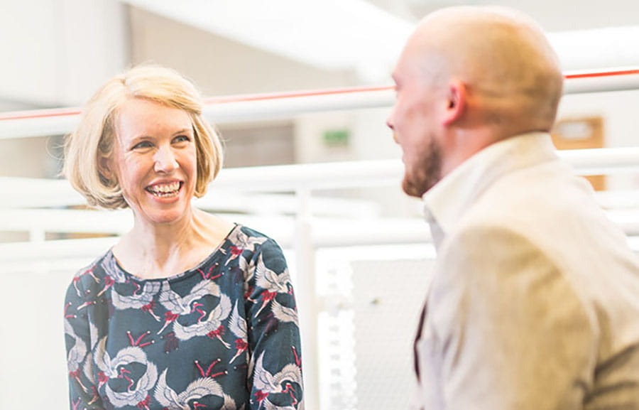 A smartly-dressed man and woman having a conversation