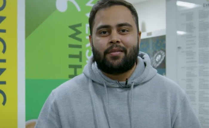An male student talks to camera in Cambridge campus