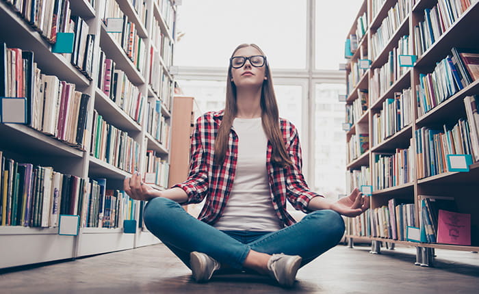 A student meditating in the library