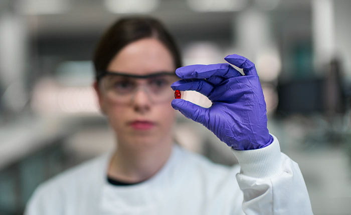 Researcher wearing lab coat, gloves and protective glasses