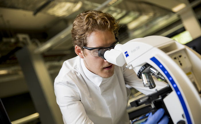 A student looking into a microscope