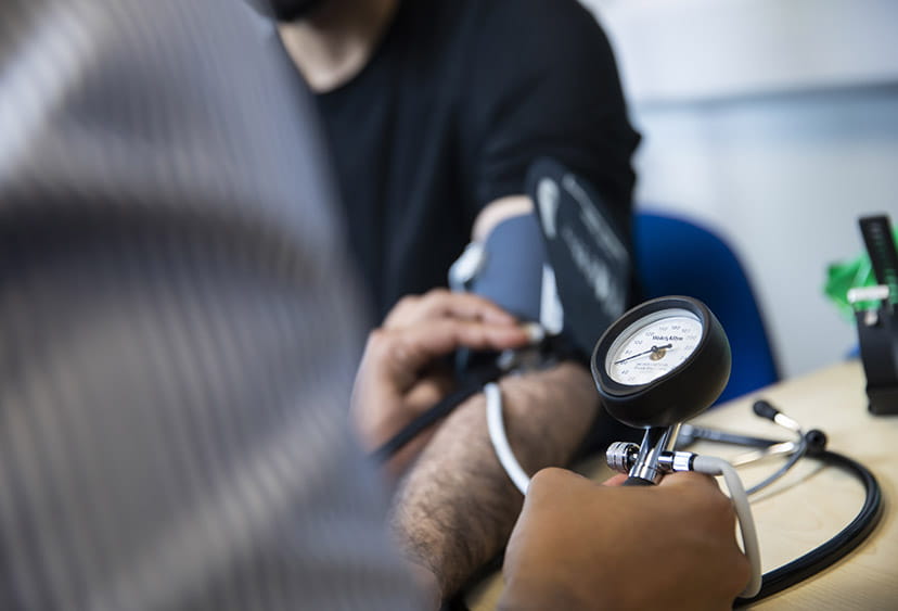 Close-up of one medical student taking another's blood pressure