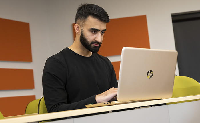 A medical student using a laptop in a lecture theatre
