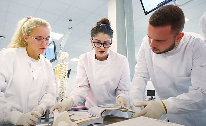 Three medical students working in a laboratory