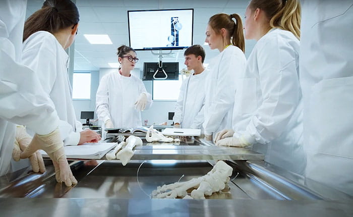 Group of medical students listening to a tutor in a laboratory