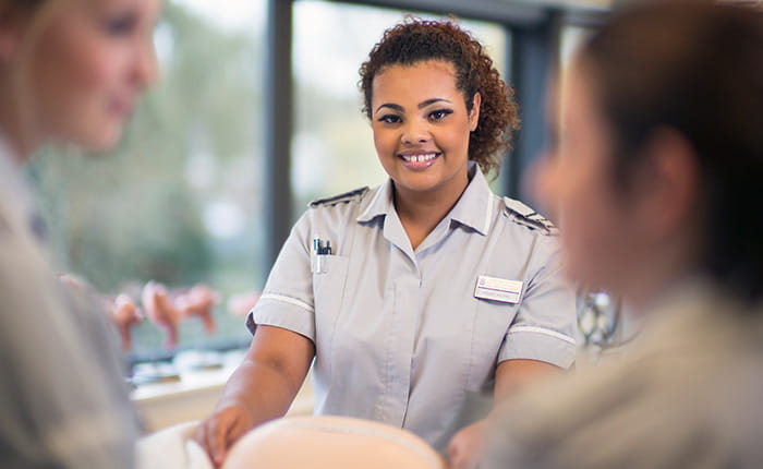 Student midwife with her hands on a patient's belly