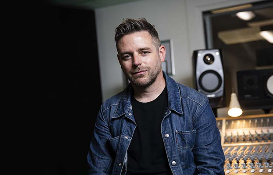 Person at a mixing desk in a recording studio
