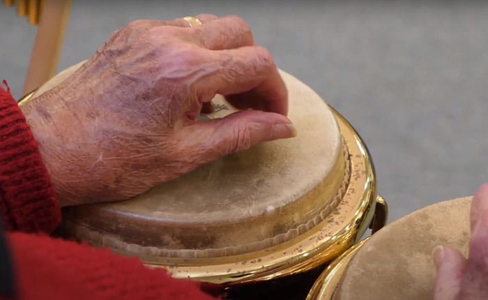 Hands resting on two bongo-type drums