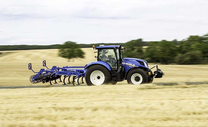 A New Holland tractor being driven across a field