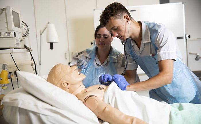 Two nursing students working on a dummy