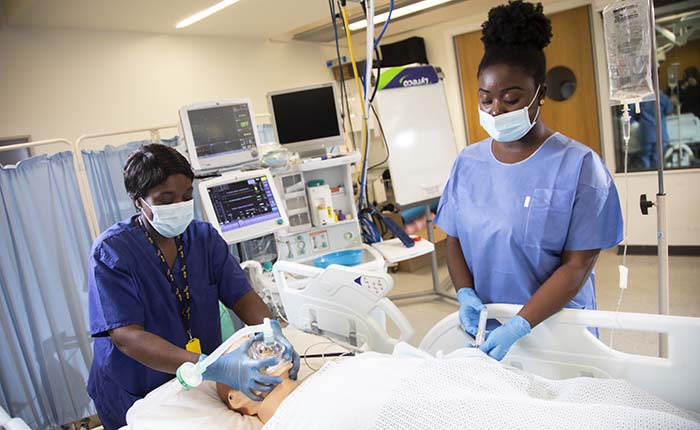 Two ODP students practicing on a dummy in the skills lab