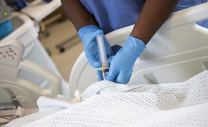 The hands of an ODP student practicing using a syringe in the skills lab