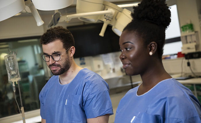 Two Operating Department Practice students listening to instructions in the skills lab