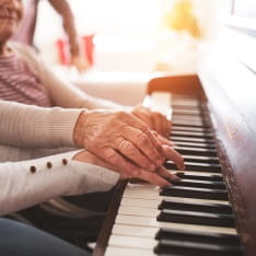 An older person playing the piano