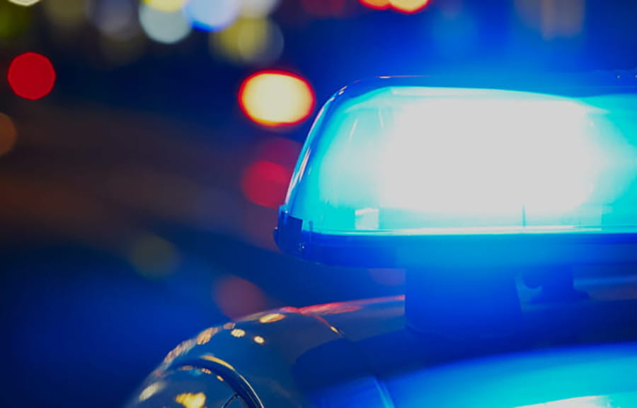 A flashing lightbar on top of a police car at night