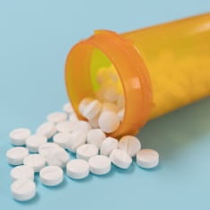 Pills spilling out of a yellow bottle